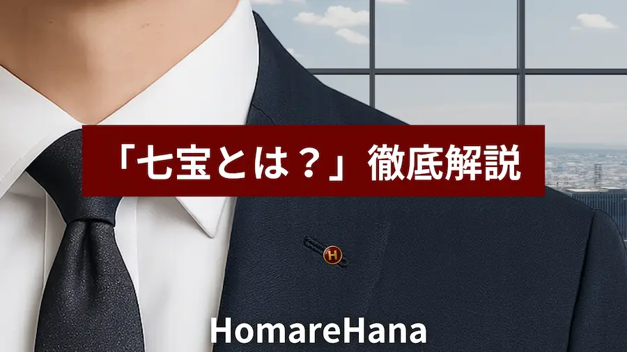 スーツを着た男性の胸元に、金色の縁と「H」の文字が入った赤い七宝焼のラペルピンがつけられており、画像中央には「七宝とは？」というテキストが重ねられている。HomareHanaの記事サムネイル用画像。