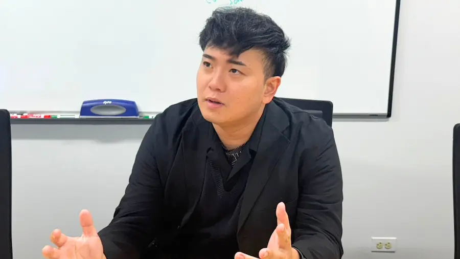 会議室でビジネスパーソンが両手を使いながら事業テーマについて説明している様子