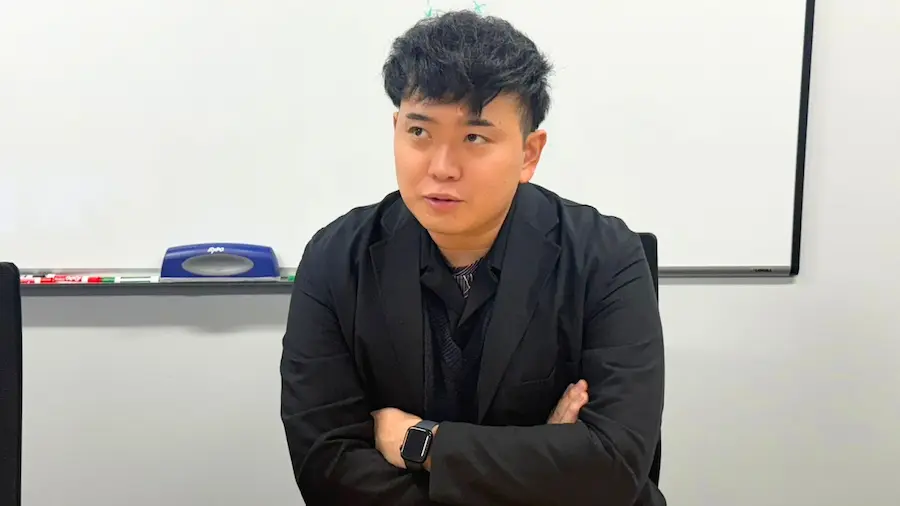 会議室でビジネスパーソンが腕を組み、事業や経営課題について考えながら話している様子
