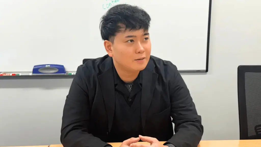 会議室でビジネスパーソンが手を組んで経営や事業について語っているインタビュー風景