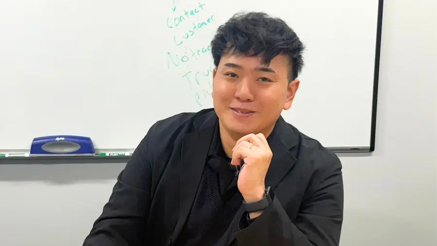 会議室でビジネスパーソンが微笑みながらインタビューに応じているビジネスシーン